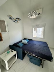 Un dormitorio con una cama azul y una mesa. en Almar Studio - Albufeira - Praia dos pescadores, en Albufeira