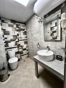 a bathroom with a white sink and a toilet at GREEN PARK Apartments and rooms for guests in Asenovgrad +28 photos