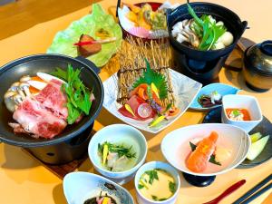 a table topped with bowls of food on a table at Awone Shirakami Juniko in Fukaura