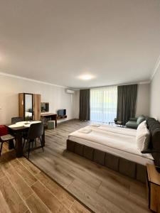 a large bedroom with a large bed and a table at GREEN PARK Apartments and rooms for guests in Asenovgrad