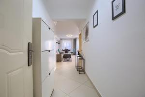 korytarz z białymi ścianami i białymi podłogami wyłożonymi kafelkami w obiekcie Comfortable apartment near the beach w Puli