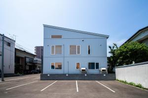a white building with two chairs in a parking lot at THE LUNA LOUNGE in Tsukisappu