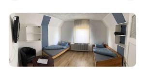 Una sala de estar con dos camas y una ventana. en Zimmer 5, en Bullendorf