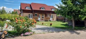 a house with a yard with flowers in front of it at Lend apartman in the garden in Miercurea-Ciuc