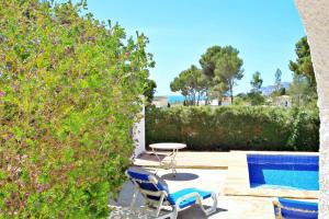 a patio with a table and chairs next to a pool at Mimosa - pretty holiday property with private pool in Moraira in Moraira