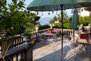 a patio with tables and chairs and an umbrella at Bed and Breakfast Casa Locarno in Locarno