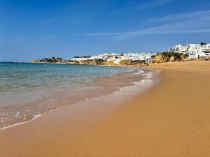 una playa de arena con edificios en el fondo en Almar Studio - Albufeira - Praia dos pescadores, en Albufeira