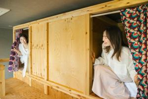 two women are sitting in a wooden room at métisse stay in Nanto +110 photos