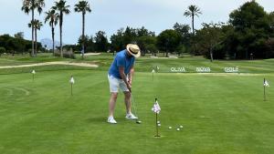 un homme joue au golf sur un parcours dans l'établissement Casa Brût - OLIVA NOVA, à Oliva