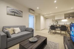 a living room with a couch and a table at Brand New 2br2ba Caulfield Parkbalcony Poolgym in Melbourne