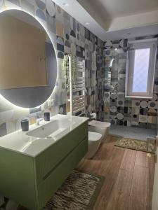 a bathroom with a sink and a toilet and a mirror at Casa vacanza Lago di Lesina in Lesina