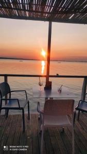 a table and chairs on a deck with the ocean at Casa vacanza Lago di Lesina in Lesina