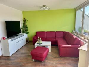 a living room with a red couch and a tv at Ferienwohnung direkt an der Elbe in Coswig