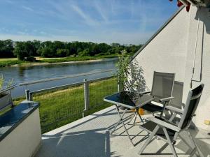 a balcony with a laptop and a table and chairs at Ferienwohnung direkt an der Elbe in Coswig