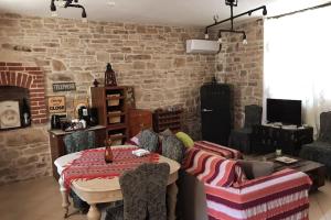 a living room with a table and a brick wall at Παραδοσιακη οικια in Flátsia