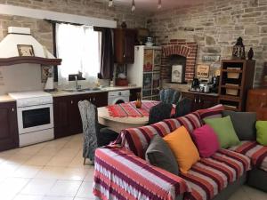 a living room with a couch and a kitchen at Παραδοσιακη οικια in Flátsia
