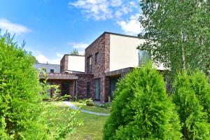 a brick house in the garden with trees at Druskininkų Šlaitas in Druskininkai