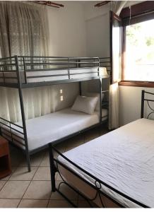 two bunk beds in a room with a window at Kali Stalonia in Nikiti