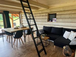 a ladder in a living room with a couch and a table at Glamping Salaš in Mochtín