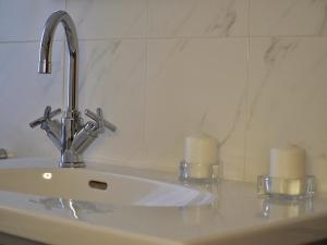 lavabo con 2 velas en la encimera en Golden House Holiday, en Belpasso