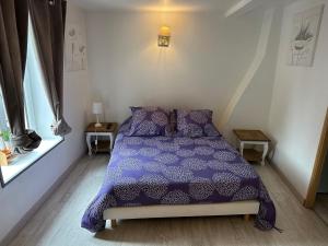 a bedroom with a purple bed and a window at maison 4 personnes tout confort alentours boulogne sur mer in Samer +12 photos