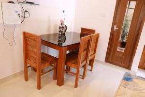 a dining room table with two chairs and a vase at Palatty Residency in Angamaly