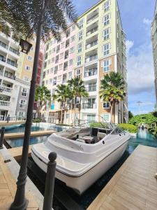 un bateau blanc est garé à côté d'un bâtiment dans l'établissement Seven Seas Cafe D'Azur, à Jomtien Beach
