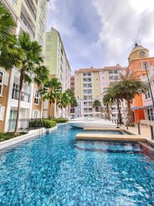 une grande piscine dans une ville bordée de palmiers dans l'établissement Seven Seas Cafe D'Azur, à Jomtien Beach