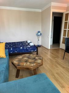 a living room with a couch and a table at Cozy apartment with balcony in Tbilisi City