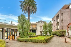 メルボルンにあるAlameda Apartment St Kilda by Ready Set Stayの建物前のヤシの木
