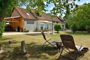 two chairs and a table in front of a house at La Bulle des alpagas in Herry
