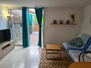 Una sala de estar con un sofá y un televisor. en Ti coin tranquille, en Étang-Salé