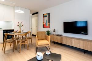 un salon avec une télévision, une table et des chaises dans l'établissement Stare Miasto z widokiem na ogród, bezpłatny parking, szybkie Wi-Fi, à Cracovie
