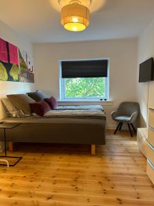 a bedroom with a bed and a window and a chair at Cozy Apartment - Søborg Great Copenhagen in Søborg