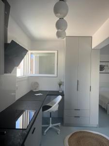 a white room with a desk and a bed at Minimal Grey Apartment Pool-front in Paros in Parikia +50 photos