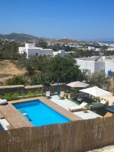 a swimming pool next to a wooden fence at Minimal Grey Apartment Pool-front in Paros in Parikia