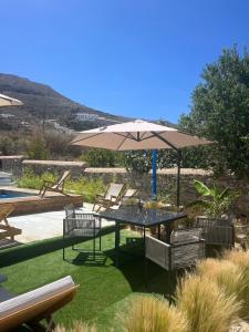 a patio with a table and an umbrella at Minimal Grey Apartment Pool-front in Paros in Parikia