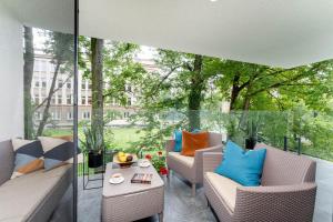 d'un balcon avec des chaises en osier et une table. dans l'établissement Stare Miasto z widokiem na ogród, bezpłatny parking, szybkie Wi-Fi, à Cracovie