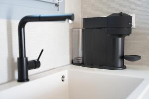 a kitchen sink with a black faucet on a counter at Pyrra apartments in Skiros +61 photos