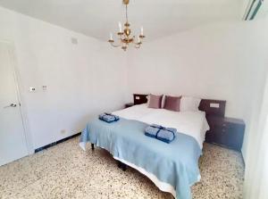a bedroom with a bed with a blue blanket and a chandelier at La casa de Pernilla Awesome apartment, near beach in centre of town in Puerto de Mazarrón