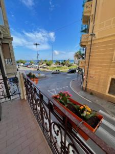 einen Balkon mit Blumen auf einer Stadtstraße in der Unterkunft Il Delfino d'Oro in Savona