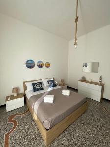 ein Schlafzimmer mit einem großen Bett und zwei Tischen in der Unterkunft Il Delfino d'Oro in Savona