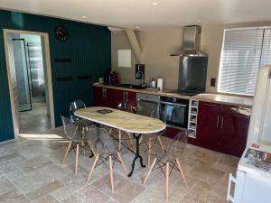 a kitchen with a table and chairs in it at Le chalet in Saint-Lubin-en-Vergonnois