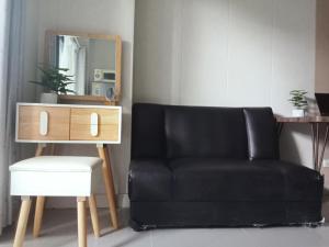 a black leather couch with a stool and a mirror at Morning cozy, airport 5-30 min in Pak Kret +11 photos