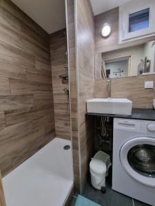 een badkamer met wastafel en wasmachine bij CHALETS JEANNE & ARNOL à Allemond - Grand Domaine Alpe d'Huez in Allemont +20 foto's