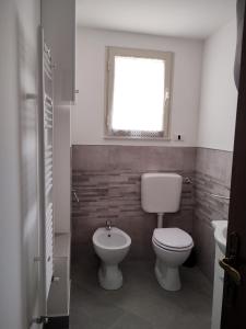a bathroom with a toilet and a window at A casa di Gigi in Zafferana Etnea +12 photos