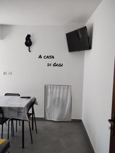a room with a table and a tv on a wall at A casa di Gigi in Zafferana Etnea