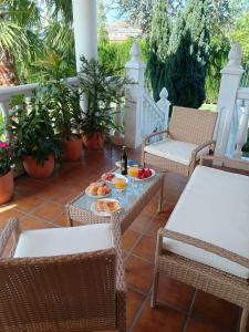 a patio with chairs and a table with food on it at Casa Rural Las cuatro flores in Órgiva