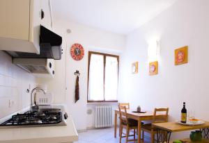 a kitchen with a stove and a table with chairs at Bright central apartment in Colle di Val d'Elsa