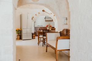 a kitchen and dining room with a table and refrigerator at Antica Tenuta dei Trulli in Alberobello